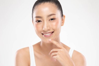 Güzel Asyalı Kadın Bakıyor Chin 'e dokunurken çok mutlu ve neşeli, sağlıklı, temiz ve taze tenli, beyaz arka planda soyutlanmış güzellik kozmetik anlayışı.