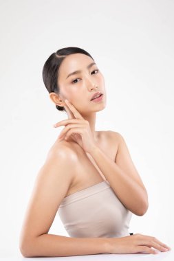 Güzel Asyalı genç bir kadın yumuşak yanaklı gülüşüne dokunuyor. Temiz ve taze tenli. Mutluluk ve neşe dolu.