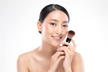 Güzel Asyalı genç kadın gülümseyecek ve makyaj fırçasıyla sağlıklı temiz ve taze bir ten hissedecek çok mutlu ve neşeli, beyaz arka planda soyutlanmış, Güzellik Konsepti