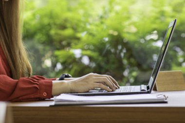 Kahve dükkanında dizüstü bilgisayarla çalışan iş kadınının eli kapalı, seçici odaklı. 