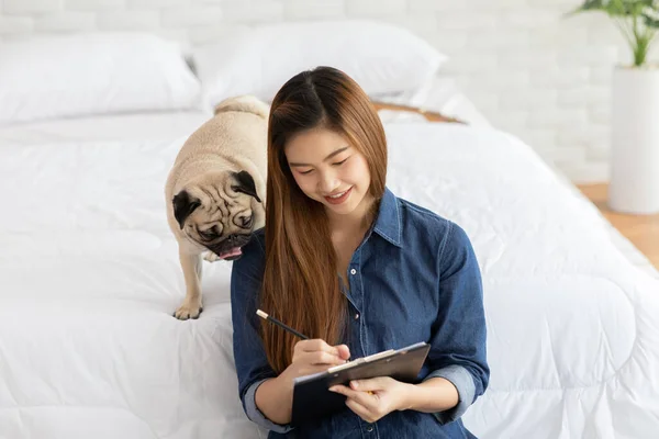 Atractivo Asiático Joven Mujer Escribiendo Libro Papel Mientras Que Perro — Foto de Stock