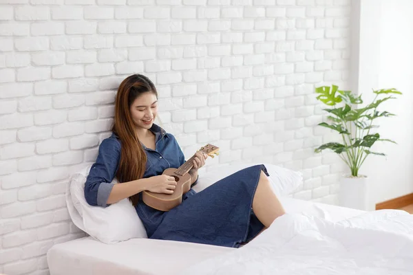 Привлекательная Азиатская Молодая Женщина Играет Ukulele Кровати Уютной Спальне Поет — стоковое фото