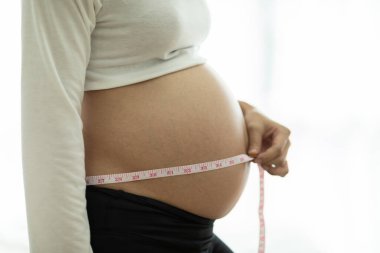 Karnını mezurayla ölçen hamile kadın, sağlıklı hamilelik konsepti, Seçici Odaklanma