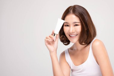 Kısa saçlı güzel bir Asyalı kadın. Lüks, beyaz, temiz bir gülümseme takınıyor. Mutlu, neşeli, sağlıklı, temiz ve taze ciltli.