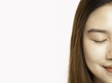 Güzel Asyalı Kadın 'ın yarı manzarası. Gözlerini kapat. Gülümse, mutlu ve neşeli, sağlıklı, temiz ve taze tenli, beyaz arka planda soyutlanmış, güzellik kozmetolojisi kavramı.