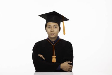 Mezuniyet gününde gururlu, gururlu, gururlu, gururlu, beyaz arka planda tecrit edilmiş, Eğitimden mezun olmuş, kep ve cüppeli Asyalı bir adam.