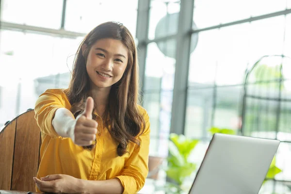 美しい魅力的なビジネスアジアの女性は モニターの笑顔でラップトップを見て作業し 親指を示すことはとても幸せので 肯定的な感情を持っています ビジネススタートアップコンセプト — ストック写真