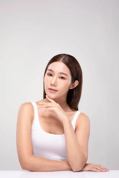 美しく若いアジアの女性は 灰色の背景に隔離された健康的な清潔で新鮮な肌でとても幸せと陽気なチン感じに触れながら 美容化粧品のコンセプト — ストック写真