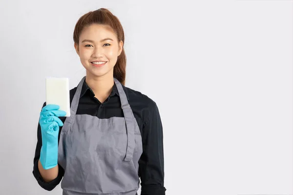 Beautiful Attractive Asian Maid smile and holding sponge for cleaning feeling so happiness and confident,Isolated on grey background,Maid Cleaning Service Concept