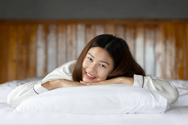 Beautiful Attractive Asian woman wearing Pajamas sleep smile sleep and sweet dream on bed in bedroom in the morning feeling so relax and comfortable,Healthcare and Sleep Concept