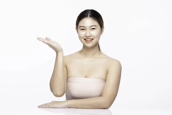 美丽迷人迷人迷人迷人的亚洲年轻女子微笑着 用白牙张开手掌展示化妆品令肌肤愉悦 与白色背景隔离 美容美发理念 — 图库照片