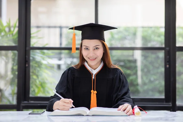 美丽迷人的亚洲女人带着毕业帽 微笑和快乐读书学习教育 教育理念 — 图库照片