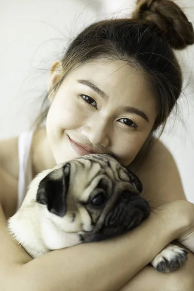아리따운 아시아인젊은 강아지와 미소짓는 모습은 침실에서 표정을 있습니다 — 스톡 사진