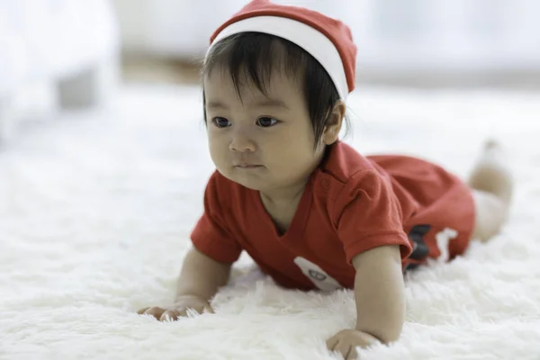 かわいい甘い愛らしいアジアの赤ちゃんは サンタの帽子と白いカーペットの笑顔に横たわっている布の衣装を着て 居心地の良いベッドルームで感情的に幸せと遊んで 健康的な赤ちゃんのコンセプト — ストック写真