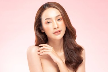 Güzel Asyalı kadın temiz ve taze tenli gülümsüyor. Mutluluk ve neşe, olumlu duygusal, pembe arka planda izole edilmiş, güzellik kozmetik ve kaplıca tedavisi kavramı.