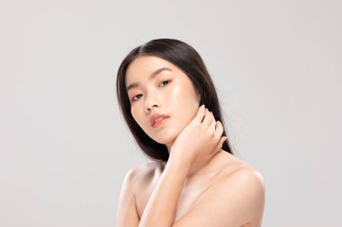 Güzel Asyalı genç bir kadın yumuşak yanaklı gülüşüne dokunuyor. Temiz ve taze tenli. Mutluluk ve neşe dolu.