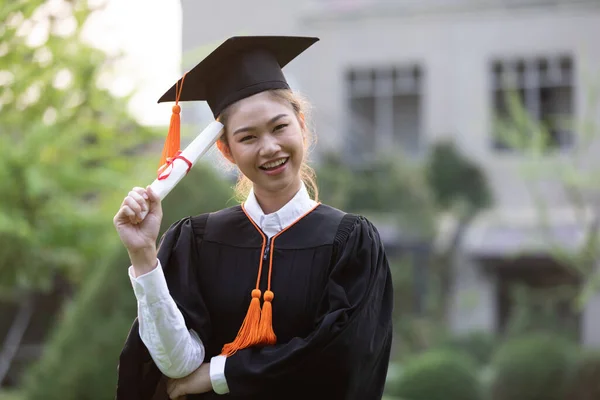 Attractive Asian Women Student Graduate in cap and gown celebrating with certificate in hand and so proud happiness in Commencement day,Congratulation of student in graduation day,Education Success