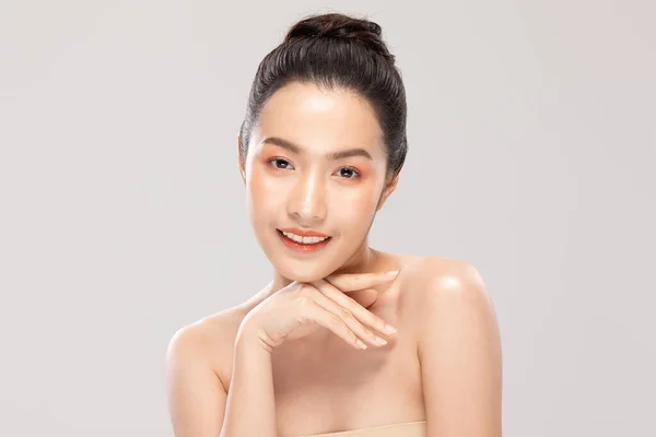 美丽的年轻亚洲女子一边摸着下巴 一边又开心又开心 有着健康而清新的肌肤 有着洁白的背景 美容美发和温泉疗养的理念 — 图库照片