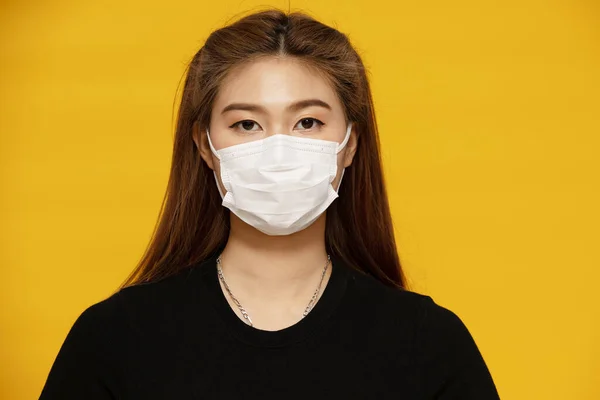 黄色の背景に保護されたウイルスや大気汚染のための保護マスクや外科マスクを身に着けているアジアの女性 ヘルスケアとコロナウイルスの概念 — ストック写真