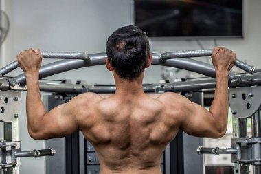 Bakış açısına göre yakışıklı genç erkekler vücut geliştirici kavramının güçlü ve güçlü hissettiği spor salonundaki sırt kaslarına odaklanırlar.