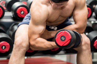 Halter kıvrımlı kas konsantrasyonu ile güçlü bir Asyalı Atletik Adam vücut geliştirme için güçlü ve güçlü hissediyor, vücut geliştirici konsept