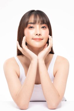 Genç ve güzel Asyalı kadın gülümsüyor yumuşak yanağa dokunuyor temiz ve taze tenli mutluluk ve neşe olumlu duygusal, beyaz arka planda izole edilmiş güzellik kozmetik ve kaplıca konsepti