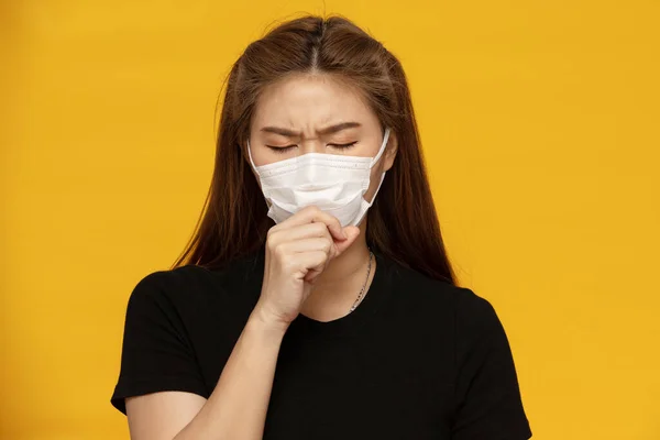 コロナウイルスや大気汚染咳から保護マスクを着用する女性黄色の背景に隔離された病気 健康管理の概念 — ストック写真