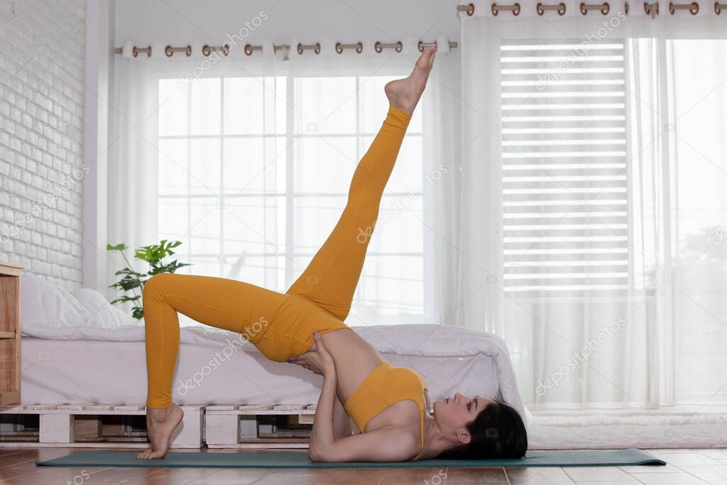 Attractive Asian woman practice yoga Shoulder stand pose to meditation in bedroom after wake up in the morning Feeling so comfortable and relax,Healthcare Concept