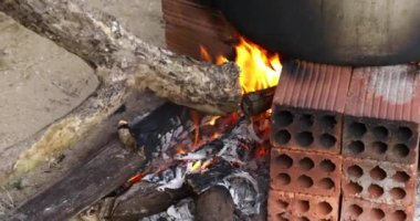 Ahşap ateşiyle yakın çekim mutfak ateşi. Ay Yeni Yılı. Pirinç keki. Kömür ocağı. Elle pişir. Orijinal yangın. 4K video