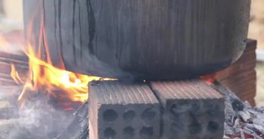 Ahşap ateşiyle yakın çekim mutfak ateşi. Ay Yeni Yılı. Pirinç keki. Kömür ocağı. Elle pişir. Orijinal yangın. 4K video