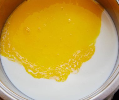 Sütün içinde süt, sütün içinde sıvı sarısı, omlet hazırlıyor. Kahvaltı evi için açık sarı sarısı beyaz süt..