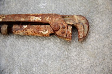 Bir anahtar betonun yüzeyinde yatıyor. Fotoğrafta eski ve paslı yatay olarak duruyor..