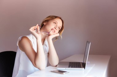 Masada kızlar günü gözlüklerle hayal kurar. Masada dizüstü bilgisayar ve telefon uzaktan çalışıyor..