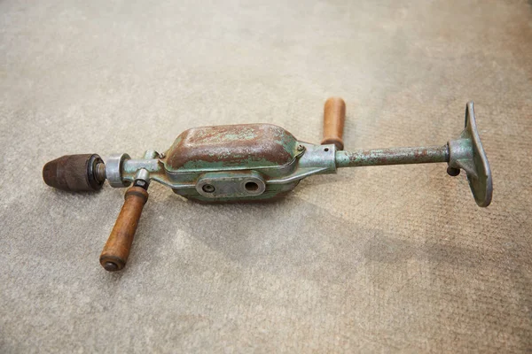 Eski mekanik paslı matkap genel planı. Gri beton bir yüzeyde bulunuyor. Yan görünüm