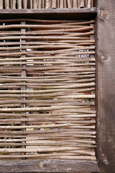 Wicker fence of twigs intertwined. Thin rods are woven into one natural fence.