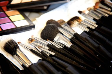 Profesyonel makyaj seti. Gölge paleti, sünger, makyaj sanatçısının bavulu, göz makyajı için dekoratif makyaj malzemeleri, parlak renklerde paletler..