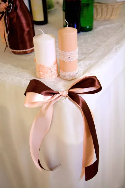 Düğün masasının dekoratif süslemeleri yumuşak pastel gölgeler, mumlar, kurdeleler. Muhteşem şeftali rengi düğün tasarımı konsepti.