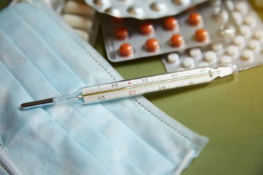Termometre masanın ve tabletin üzerinde. Virüs ve pandemik koronavirüs en iyi doktorlar tarafından tedavi ve iyi sağlık