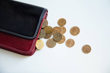 Cüzdandan demir paralar dökülüyor. Banknotlar, eski madeni paralar, yoksulluk, etrafa saçılmış paralar, beyaz arka plan.