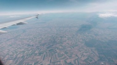 Uçan bir kanat uçağının penceresinden görünüm.