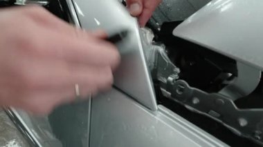 Gümüş spor arabalardaki PPF kurulum işlemine yakın. PPF, boyayı çiziklerden ve taş parçalarından koruyan bir boya koruma filmidir..