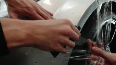 Gümüş spor arabalardaki PPF kurulum işlemine yakın. PPF, boyayı çiziklerden ve taş parçalarından koruyan bir boya koruma filmidir..