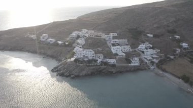 Tinos Adası 'ndaki birkaç beyaz eve bakan İHA uçağı iniyor.
