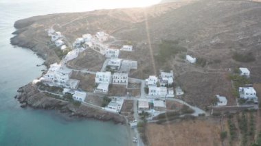 Tinos adasındaki birkaç beyaz evi çevreleyen hava aracı uçuşu.