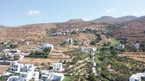 ギリシャのティノスの丘の上にいくつかの家がある乾燥した山の風景の方への空中ドローン飛行 — ストック動画