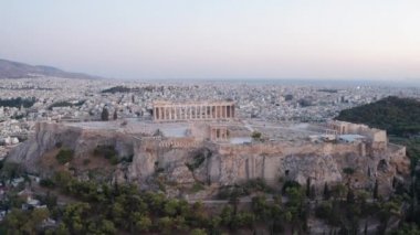 Parthenon Antik Akropolis üzerinde günbatımında Atina 'nın arka planında bir İHA uçuyor