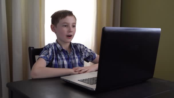 4Kだ 驚くべき10歳の子供は 恐ろしい映画を見ながら彼の手で彼の目をカバーし ショックと怖い表情でコンピュータ画面を見ています インターネットの危険性 — ストック動画