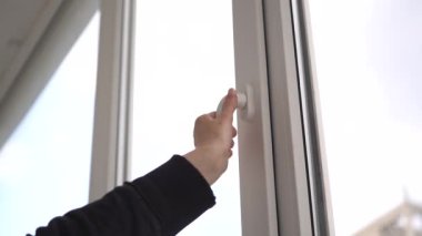 Kadın sapından beyaz plastik bir pencere açar ve kapatır..