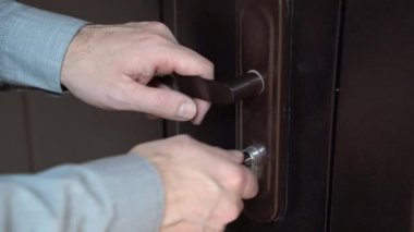 4 bin. Adam anahtar kullanıyor, ön kapının kilidini açıp kapatıyor, yakın plan. Evinizin ya da dairenizin güvenliği ve korunması .