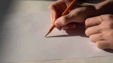 4 bin. Bir erkek / öğrenci beyaz bir çarşafa kurşun kalemle çizer. Erkek bir moda tasarımcısı kıyafet için eskizler hazırlar. Kapat..